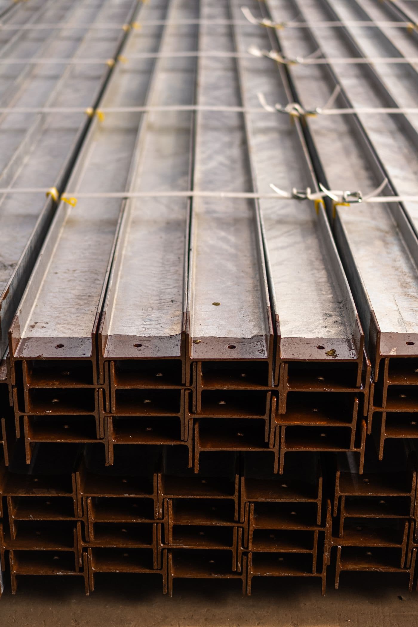 Neatly stacked steel beams in a supply yard